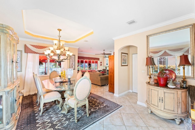 dining room with a raised ceiling, crown molding, light tile patterned floors, and ceiling fan with notable chandelier