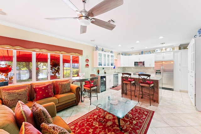 tiled living room with beverage cooler, ornamental molding, and ceiling fan