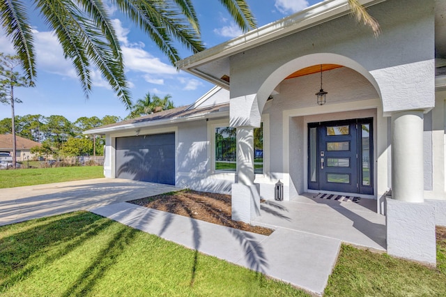 doorway to property featuring a garage and a lawn