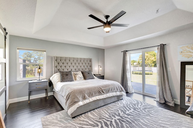 bedroom featuring access to outside, a raised ceiling, ceiling fan, and dark wood-type flooring