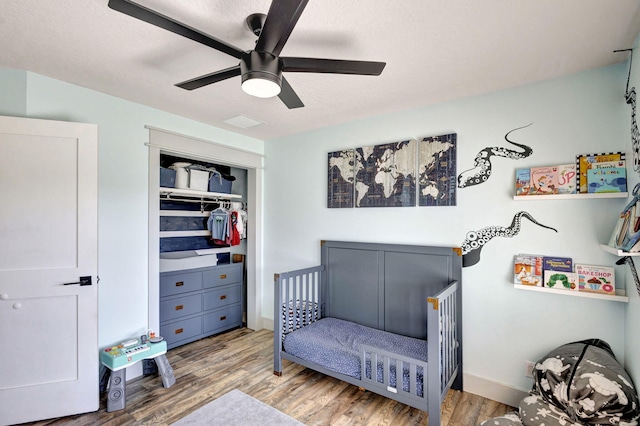 bedroom with hardwood / wood-style flooring, ceiling fan, and a closet