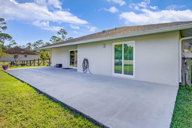 back of house featuring a lawn and a patio area