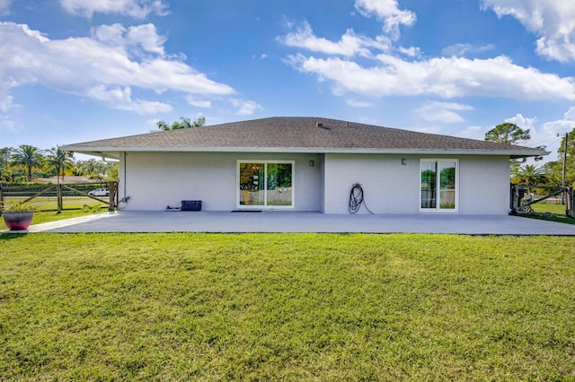 rear view of property with a lawn and a patio