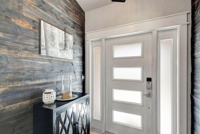 entryway with plenty of natural light and wooden walls