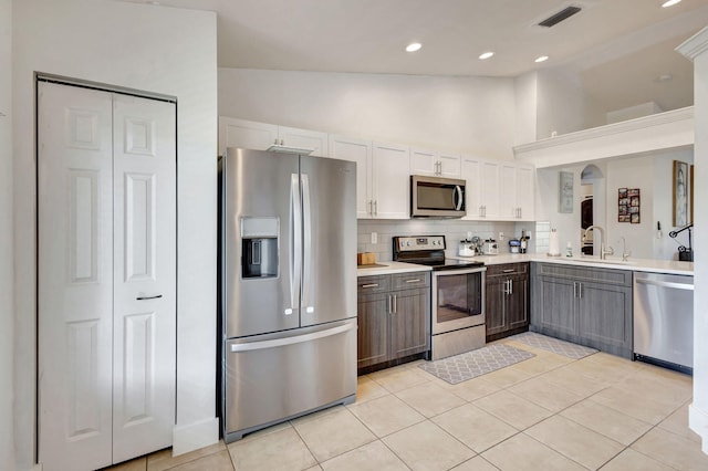 kitchen featuring white cabinets, light tile patterned floors, appliances with stainless steel finishes, and tasteful backsplash