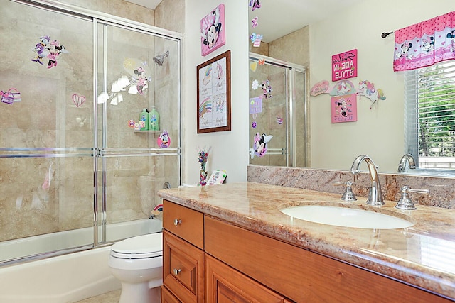 full bathroom with vanity, enclosed tub / shower combo, and toilet