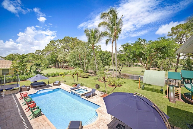 view of swimming pool featuring a lawn, a patio area, a playground, and an in ground hot tub