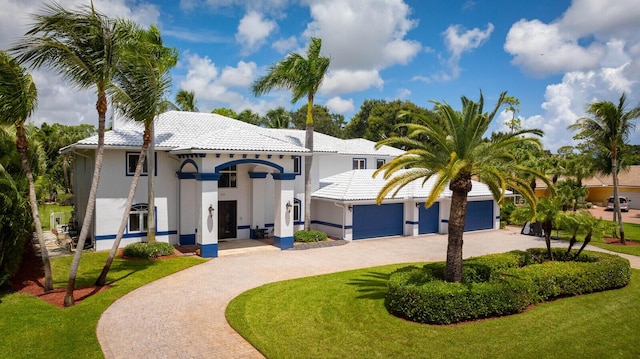 mediterranean / spanish house featuring a front yard and a garage