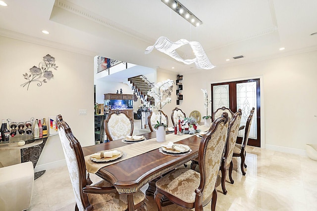 dining room featuring a tray ceiling and ornamental molding