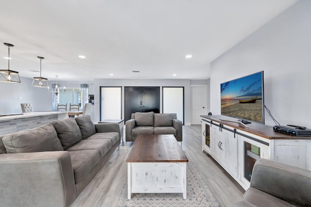 living room with a notable chandelier and light hardwood / wood-style floors