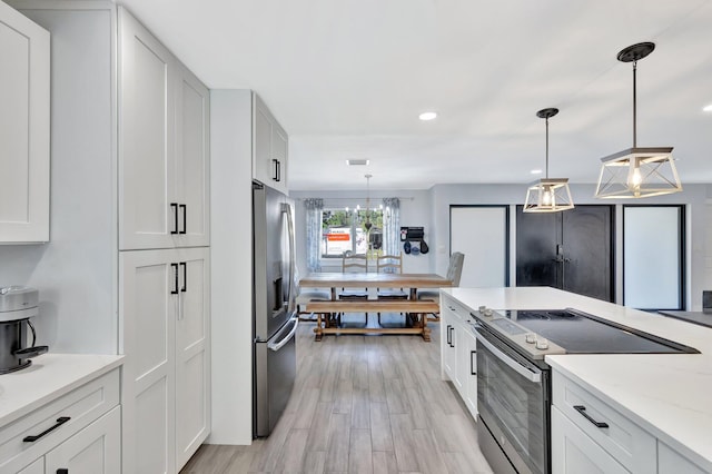 kitchen with pendant lighting, white cabinets, and stainless steel appliances