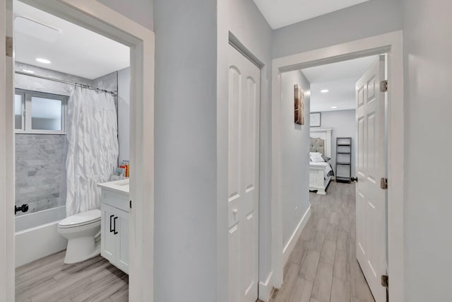 full bathroom featuring shower / bath combo, vanity, hardwood / wood-style flooring, and toilet