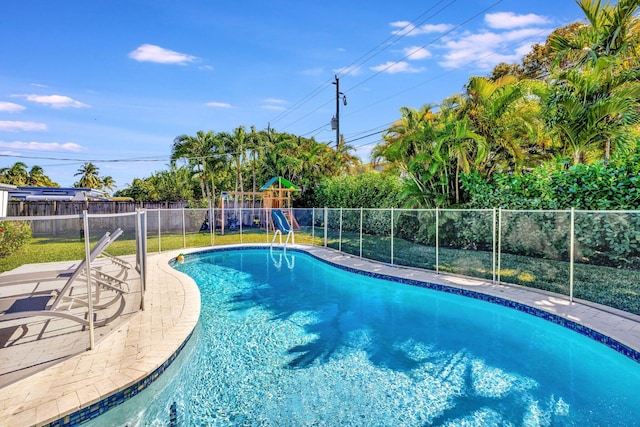 view of swimming pool with a playground and a patio