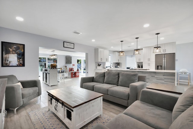 living room with light hardwood / wood-style flooring and sink