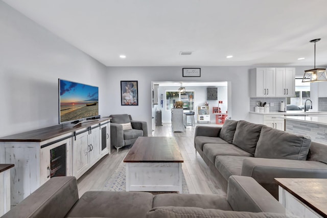 living room with light hardwood / wood-style floors and sink