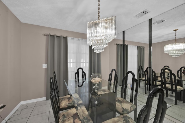 tiled dining area with a textured ceiling and an inviting chandelier