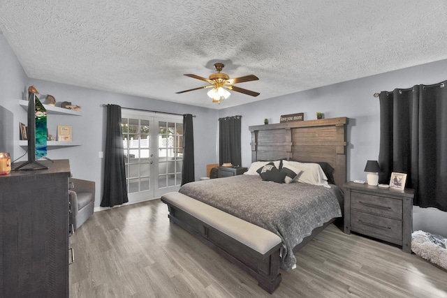 bedroom with ceiling fan, french doors, a textured ceiling, and light hardwood / wood-style flooring