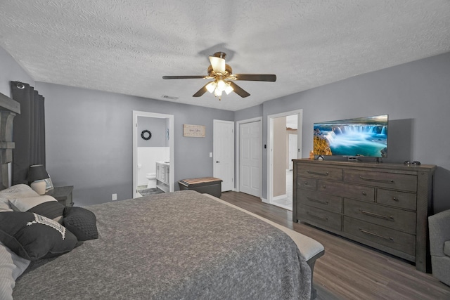 bedroom with a textured ceiling, connected bathroom, dark hardwood / wood-style floors, and ceiling fan