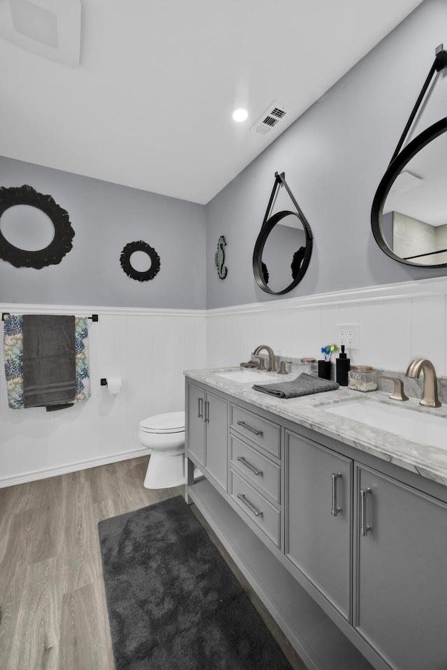 bathroom with hardwood / wood-style floors, vanity, and toilet