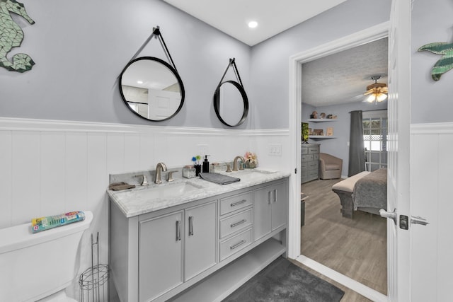 bathroom with vanity, hardwood / wood-style flooring, toilet, and ceiling fan