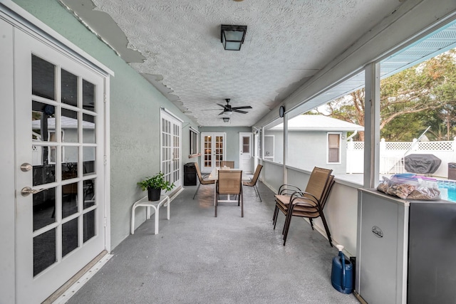 unfurnished sunroom with ceiling fan