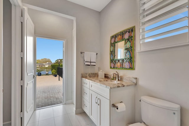 bathroom with tile patterned flooring, vanity, and toilet