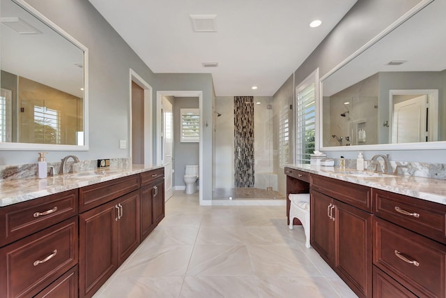 bathroom featuring vanity, a wealth of natural light, an enclosed shower, and toilet