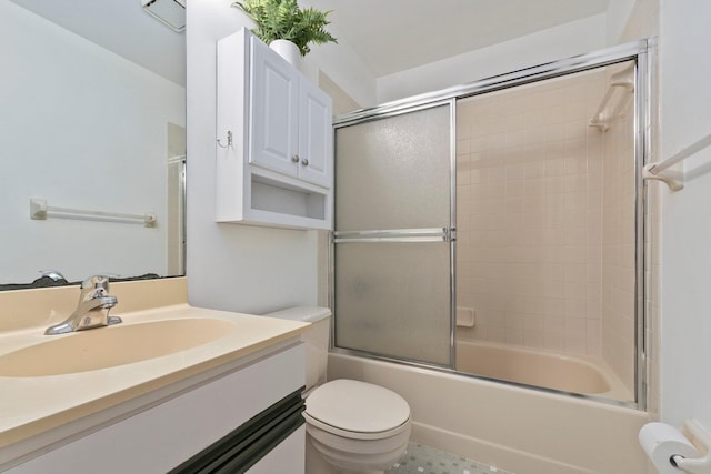 full bathroom featuring vanity, bath / shower combo with glass door, and toilet