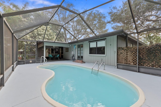 view of swimming pool with french doors, glass enclosure, ceiling fan, and a patio area