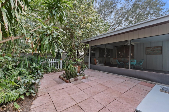 view of patio / terrace featuring ceiling fan and a sunroom