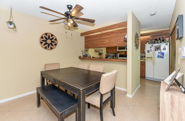 tiled dining space featuring ceiling fan and a textured ceiling