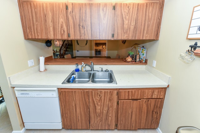 kitchen with sink, white dishwasher, and light tile patterned floors