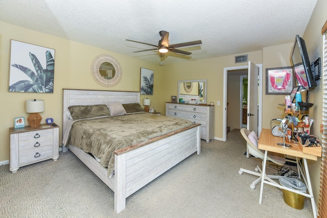 carpeted bedroom featuring ceiling fan and a textured ceiling