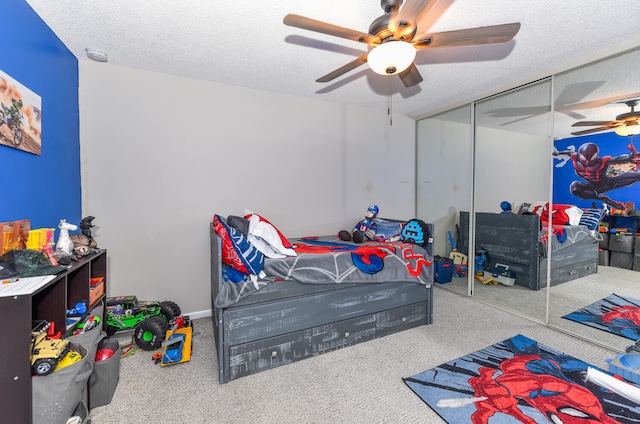 bedroom with carpet flooring, a textured ceiling, a closet, and ceiling fan