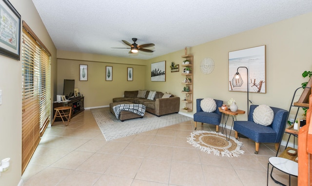 living room featuring a textured ceiling, ceiling fan, and light tile patterned flooring