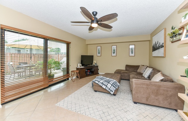 tiled living room featuring ceiling fan and a textured ceiling