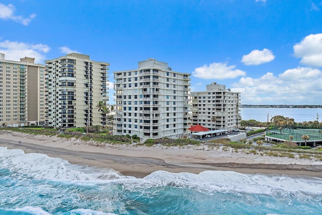 view of building exterior featuring a water view and a view of the beach