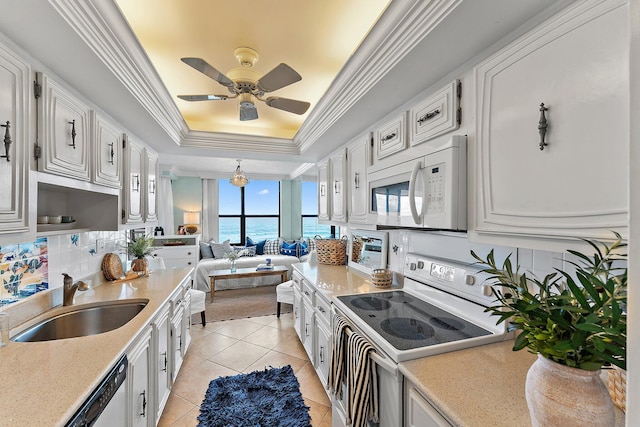 kitchen featuring white appliances, a water view, white cabinetry, and sink