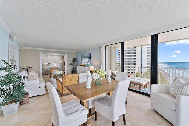 tiled dining space featuring a textured ceiling, a water view, crown molding, and a wealth of natural light