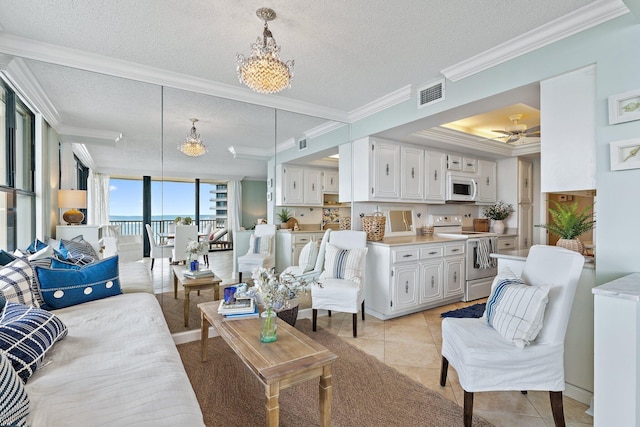 tiled living room featuring crown molding, ceiling fan with notable chandelier, and a textured ceiling