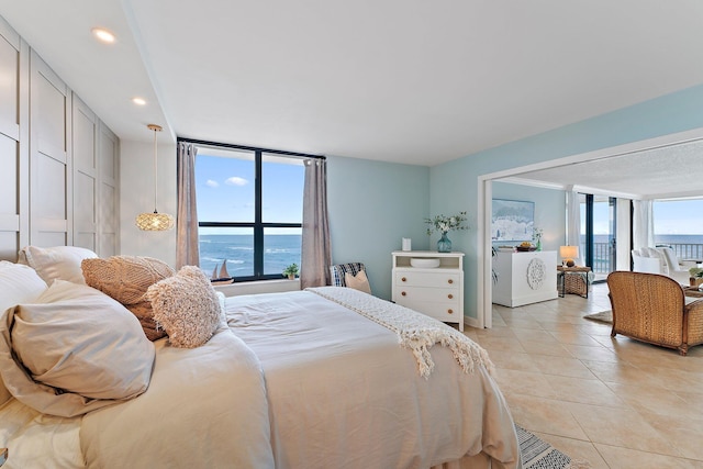 tiled bedroom featuring floor to ceiling windows and a water view