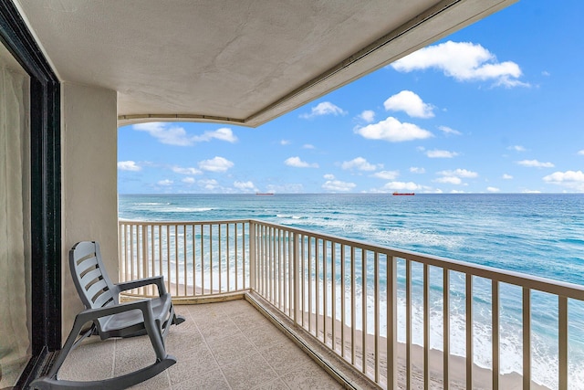 balcony with a water view and a beach view