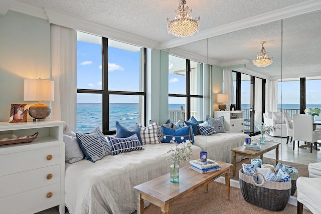 living room featuring a notable chandelier, expansive windows, a water view, and plenty of natural light