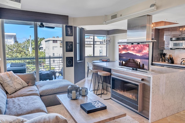 living room with ceiling fan with notable chandelier