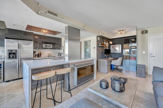 kitchen with a center island with sink, sink, wine cooler, decorative backsplash, and stainless steel fridge with ice dispenser