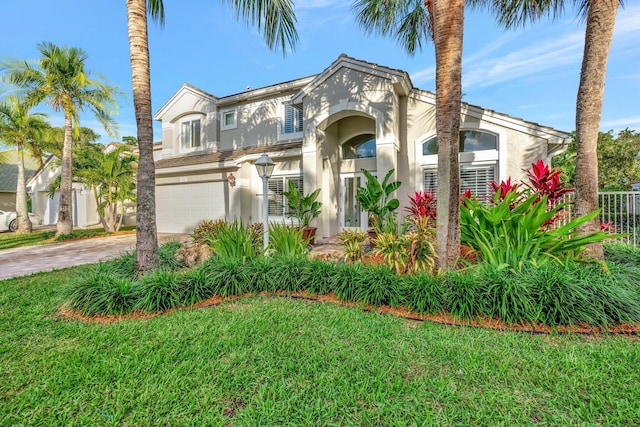 mediterranean / spanish house with a front lawn and a garage