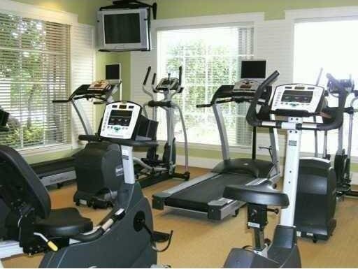 workout area featuring a towering ceiling and a healthy amount of sunlight