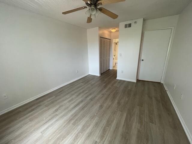 spare room with ceiling fan, dark wood-type flooring, and a textured ceiling