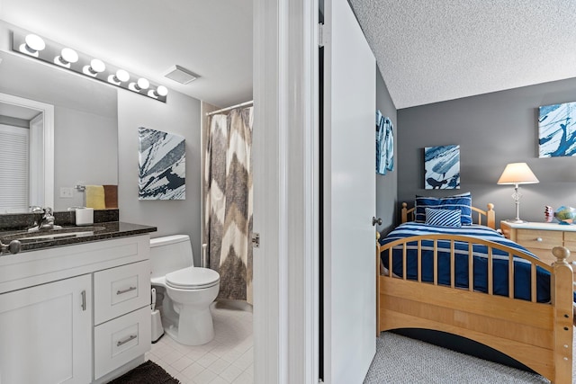 bathroom featuring tile patterned floors, vanity, toilet, and a textured ceiling