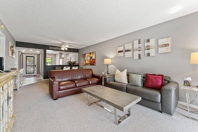 living room with ceiling fan, light carpet, and a textured ceiling